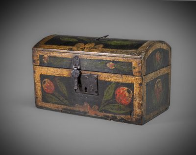 un vieux coffre en bois muni d'une serrure et orné de fleurs peintes