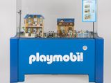 une vitrine Playmobil bleue contenant une maison de poupées