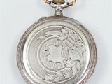 a silver pocket watch on a chain on a white surface