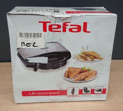 emballage d'un appareil à sandwichs Tefa posé sur une table en bois