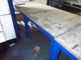 an image of a table in a garage with a refrigerator in the background