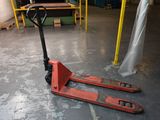 un chariot élévateur posé au sol dans un entrepôt