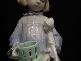 a figurine of a little girl holding a basket