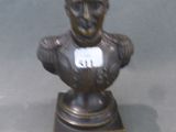 statue représentant le buste d'un homme, sur laquelle est apposée une étiquette avec son nom