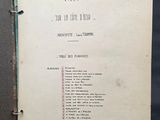 un vieux livre ouvert sur une page où figure la liste d'objets posés sur une table
