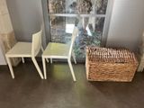 two chairs and a basket in front of a window