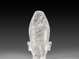 crystal head of a man on a white surface with a black background