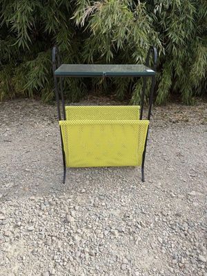 a yellow bench sitting in the middle of a gravel road