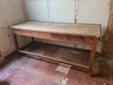 une table en bois surmontée d'un tiroir, placée dans un coin de la pièce