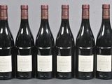 six bottles of wine are lined up in a row on a table