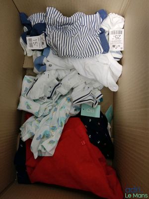 une boîte en carton remplie de vêtements pour bébé et de couches