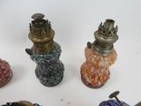 four different colored glass vases on a white surface