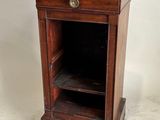 une vieille armoire en bois avec un plateau en marbre, posée sur un sol blanc