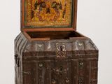 an old wooden chest with a painting on it sitting on top of a table
