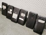 several cell phones are lined up against a wall in a row