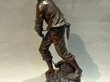 bronze statue of a man with a dog on a rock
