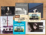 plusieurs livres posés sur une table, avec une photo de voiture en arrière-plan