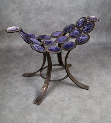 une image représentant un bol en verre violet posé sur un socle en métal