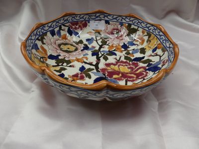 un bol orné de fleurs, posé sur une nappe blanche