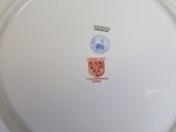 a white plate with a red and blue emblem on it
