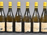 six bottles of wine are lined up in a row on a table