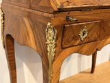 a small wooden desk with a drawer on top of it