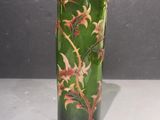 a green glass vase with red and yellow flowers on it