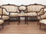 plusieurs chaises et une table dans une pièce, avec un mur en arrière-plan