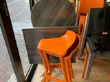 des tables et des chaises devant une fenêtre, avec une personne debout à l'arrière-plan