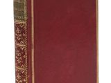un vieux livre à la couverture rouge et à la bordure dorée