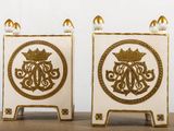 pair of white and gold painted candlesticks with a crown on top