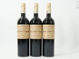 three bottles of wine sitting on top of a white table