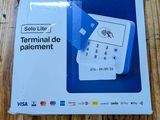 La boîte est ouverte sur une table en bois et contient une télécommande.
