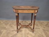 an old wooden table with a marble top on a parquet floor