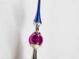 multicolored glass bead hanging from a metal pole with a blue top