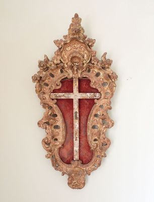 a cross hanging on the wall in the corner of a room