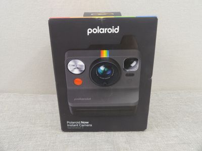 une photo représentant un appareil photo Polaroid posé sur une boîte