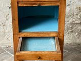 a small wooden table with a blue drawer on it