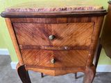 a small wooden table with a marble top on it