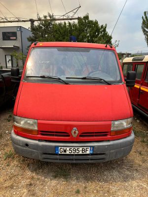 une camionnette rouge garée à côté d'autres voitures
