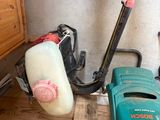 a green and black blower sitting on the floor next to a green and white blower
