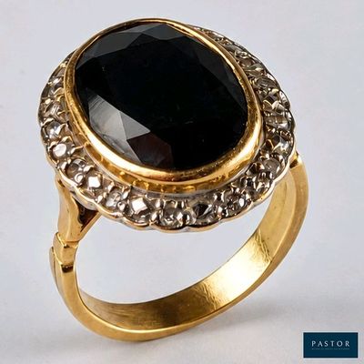 Gros plan sur une bague en or ornée d'une pierre noire