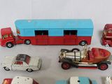 many toy cars and a bus on a white surface