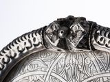 a silver plate with two monkeys on it