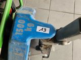 un cyclomoteur bleu et vert posé par terre à côté d'une personne