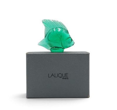 a close up of a green glass fish on top of a box