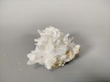 quartz crystal cluster on a plate on a white surface