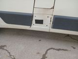 a broken door on a van that is parked on the street