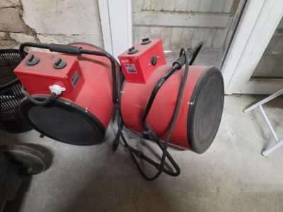 un ventilateur rouge posé par terre à côté d'un panier