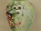 a vase with a painting on it sitting on a table